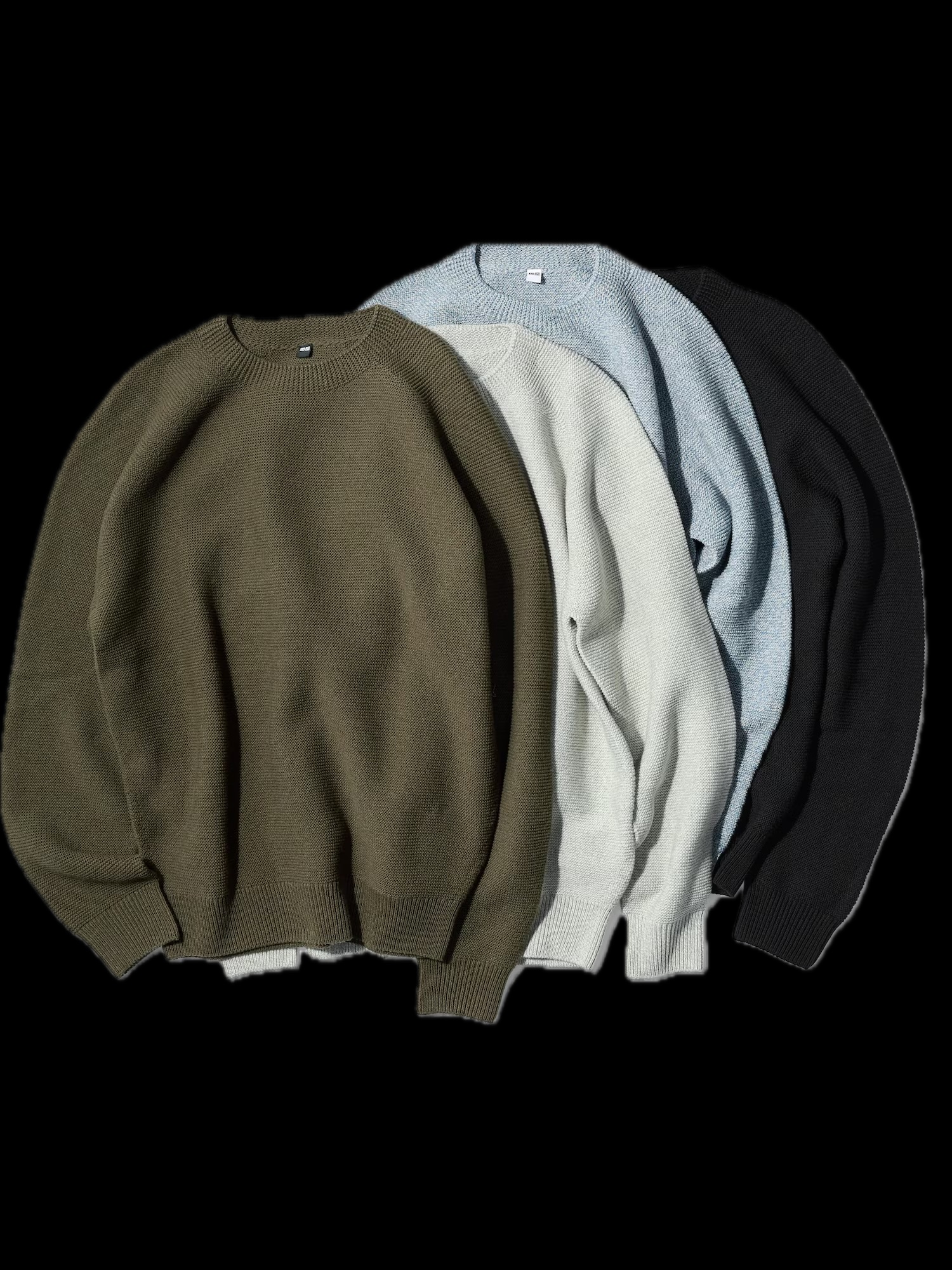 Stack of crewneck sweaters in neutral colors